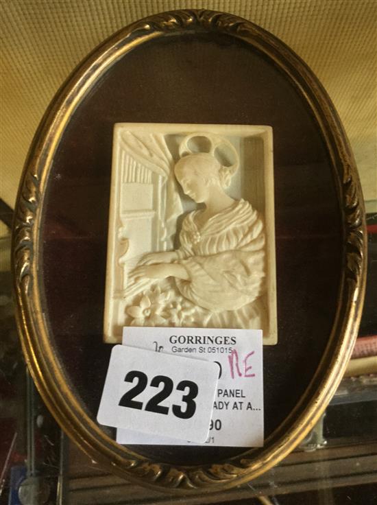 Framed ivory panel carved with a lady at a piano(-)